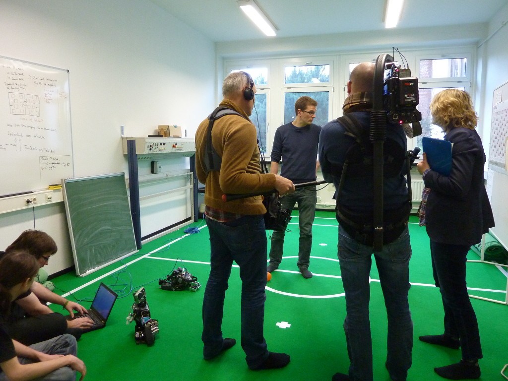 Substanzredakteure und NDR-Kamerateam auf dem Spielfeld